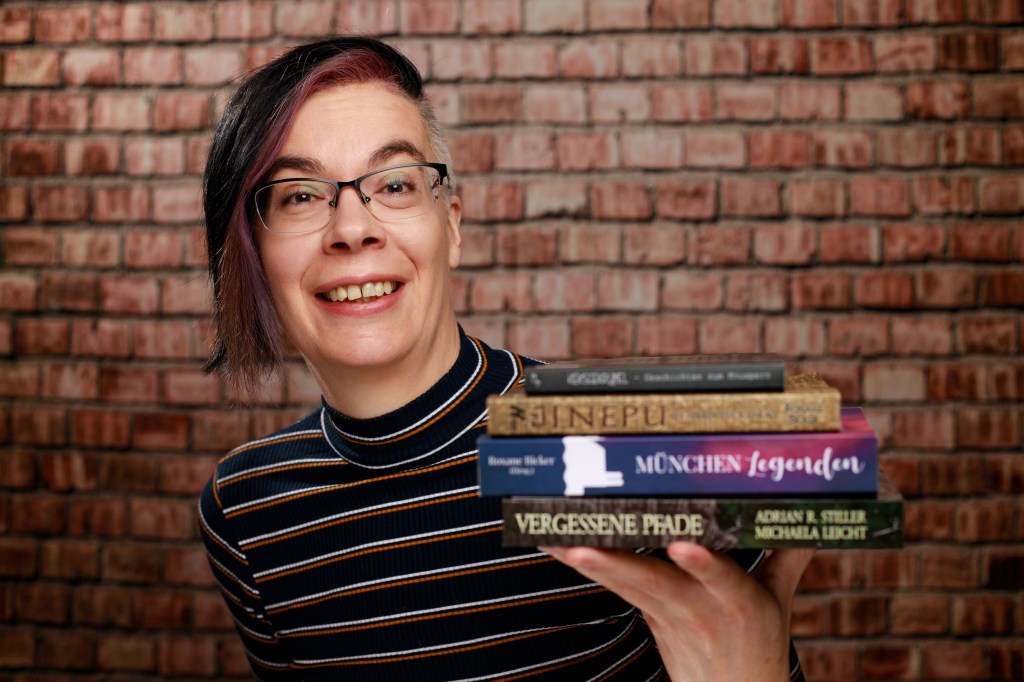 Lachen hält Roxane vier Bücher ins Bild