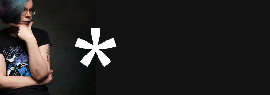 Roxane hält die Hand am Kinn und schaut kritisch auf einen *